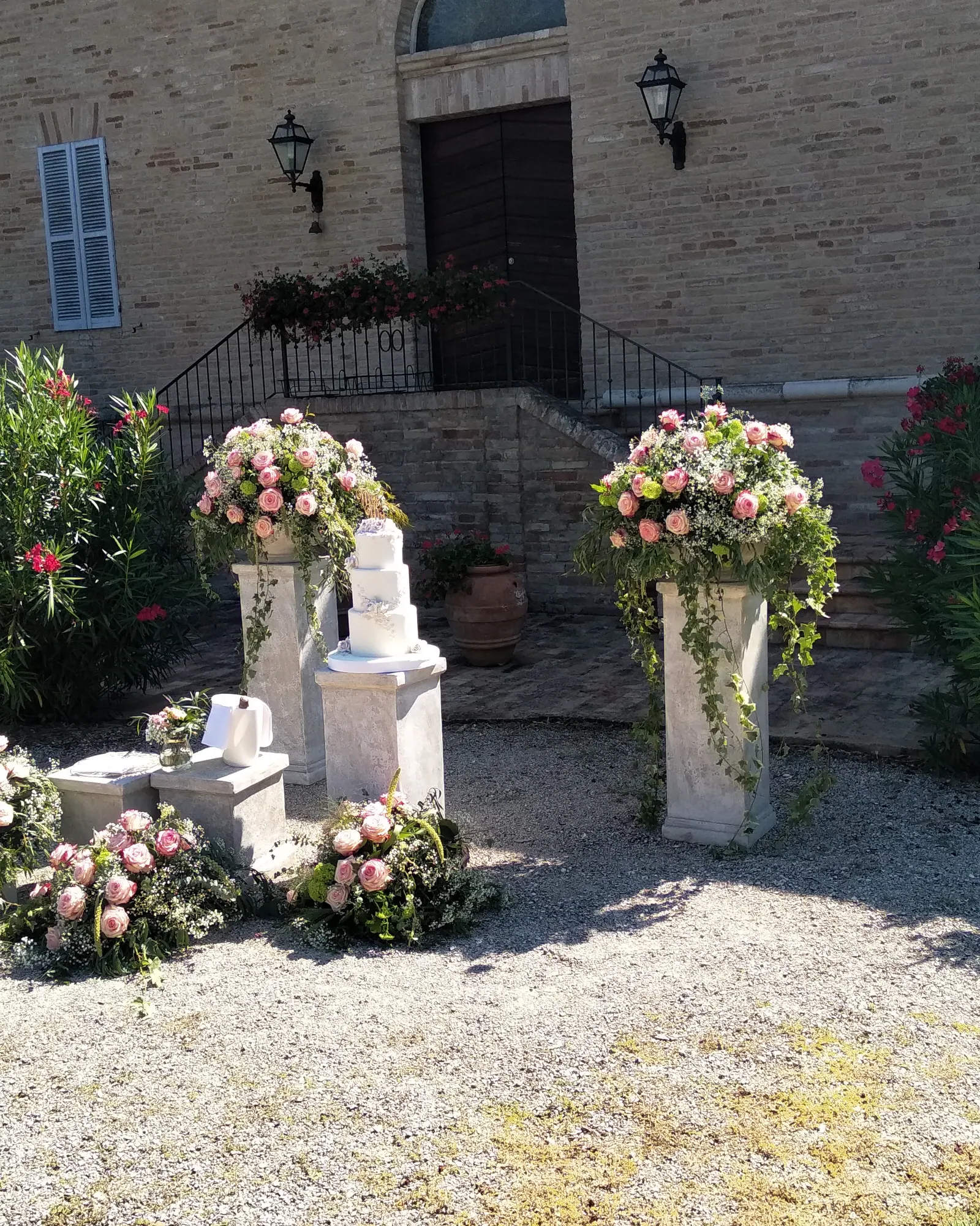 L'ingresso della villa addobbato con colonne di rose rosa e bianche